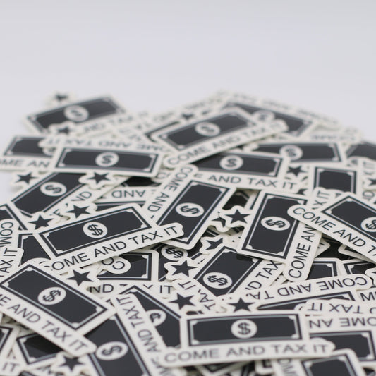 A pile of stickers that have the Come and tax it logo